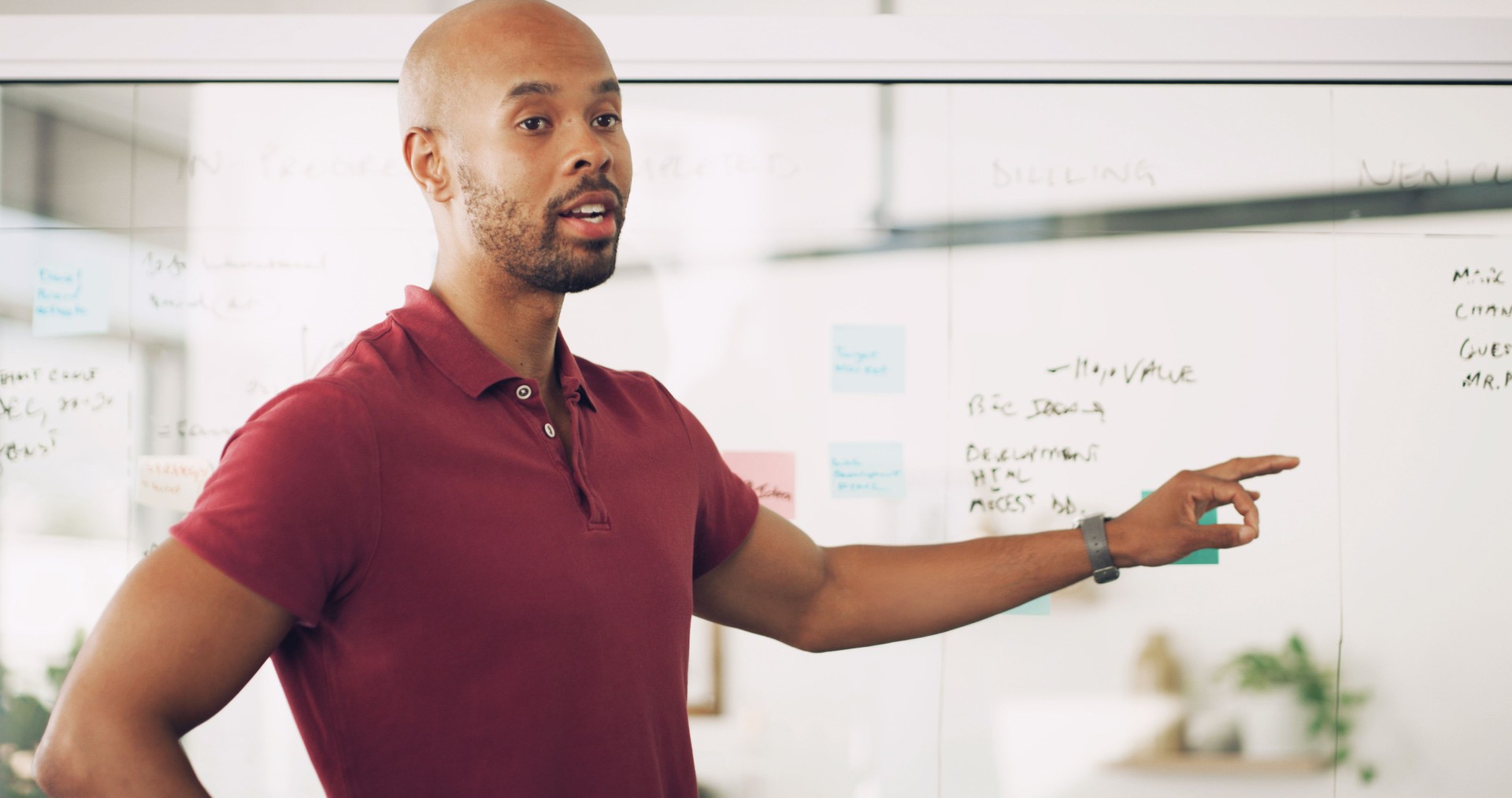 Presentation, talking and man with info, office and glass board with notes, training and newsroom. Pointing, journalist and black person with plans for project, advice and public speaking in workshop